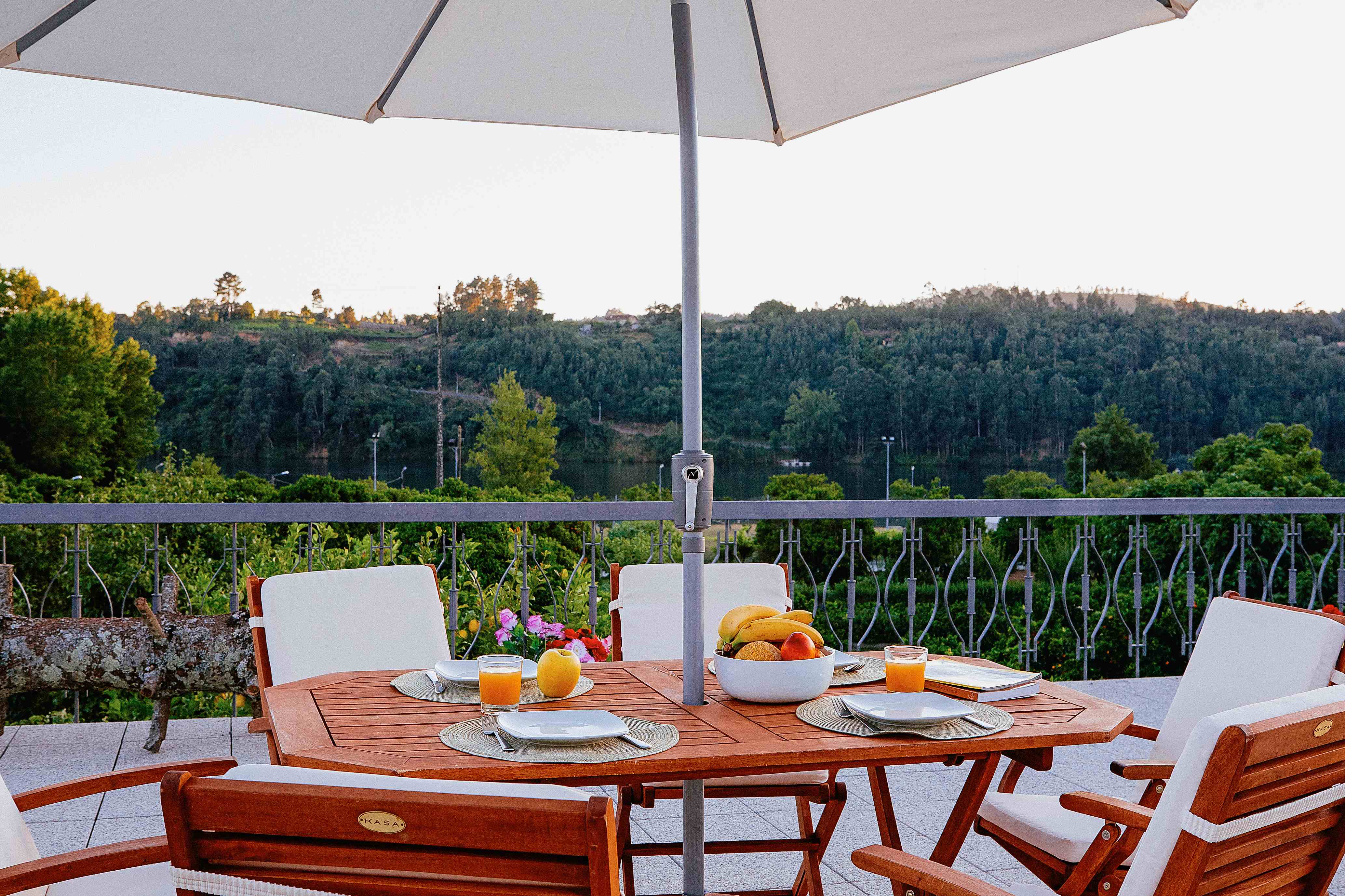 Terraço com mesa de refeições e vista para o rio